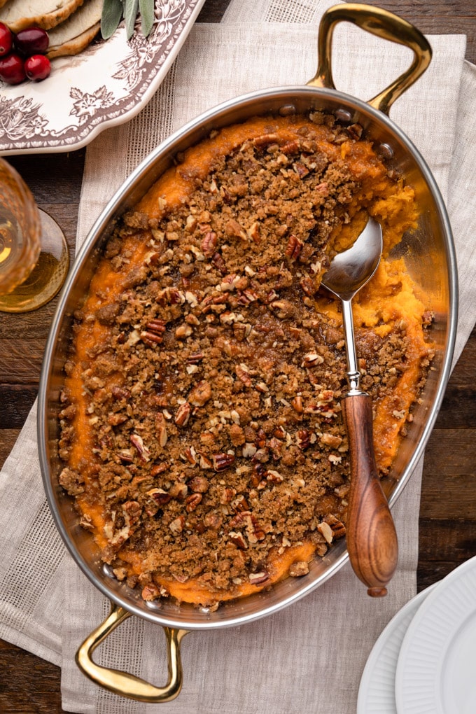 overhead of sweet potato casserole in a gratin pan on a Thanksgiving table