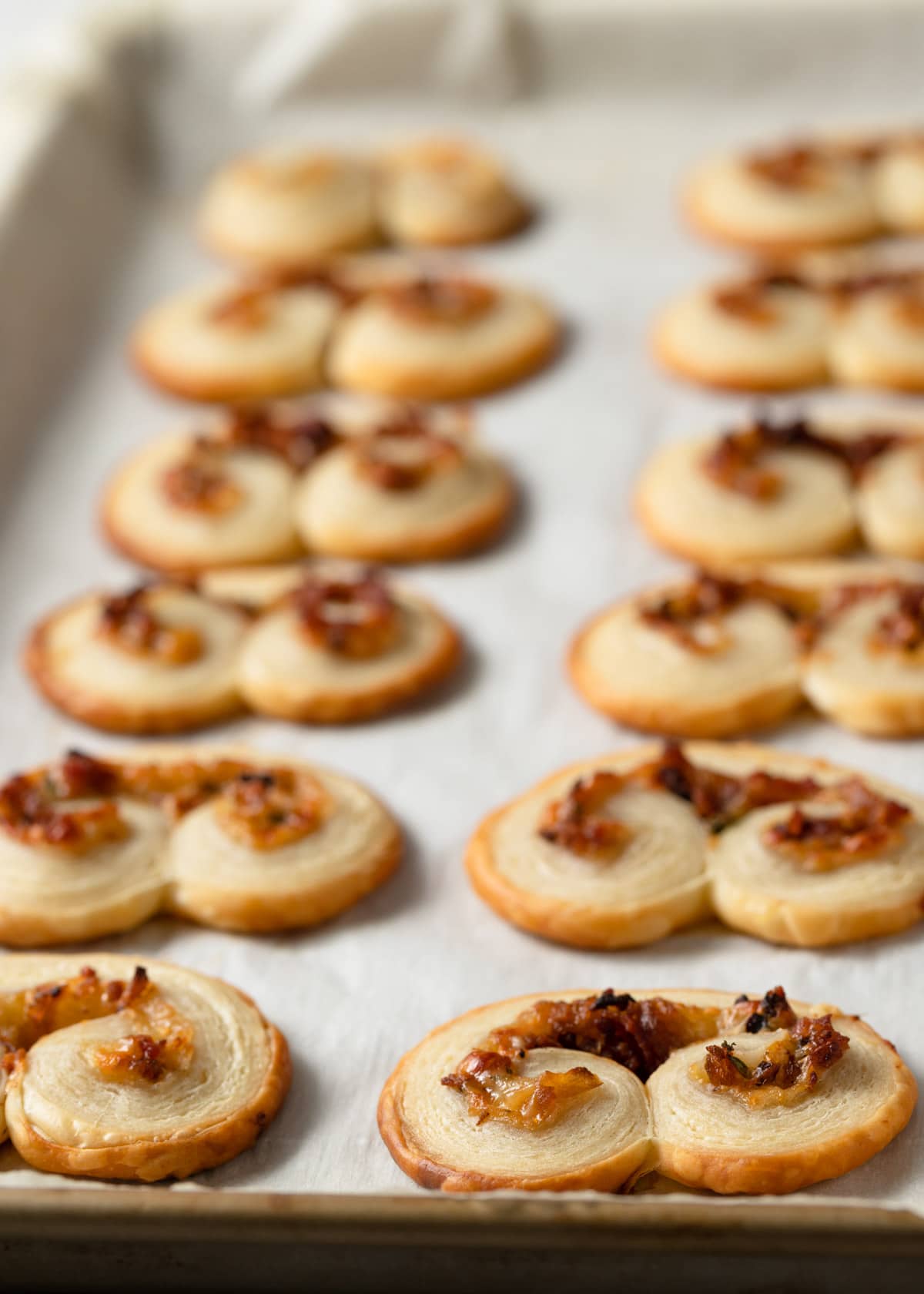 baked savory palmiers on a pachment-lined baking sheet