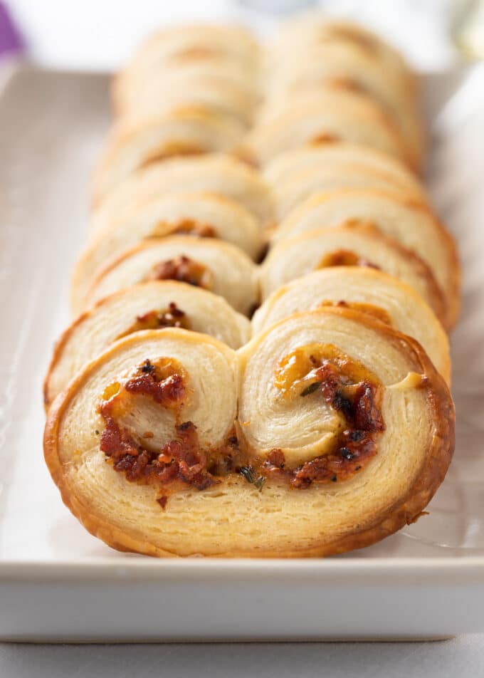 closeup of savory palmiers with bacon on a white serving platter