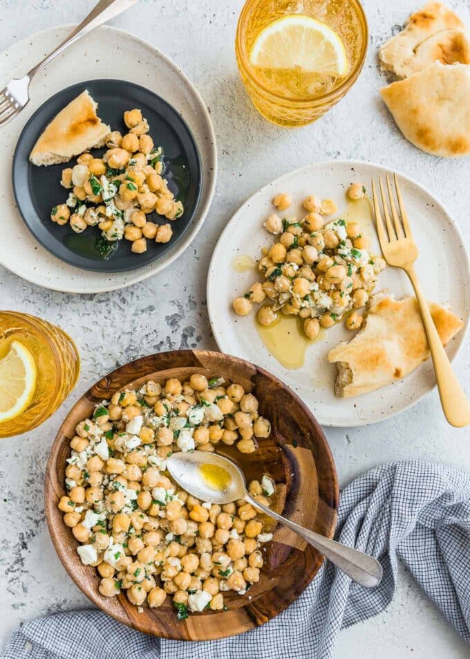 bowl of chickpea salad served onto plates with torn naan bread