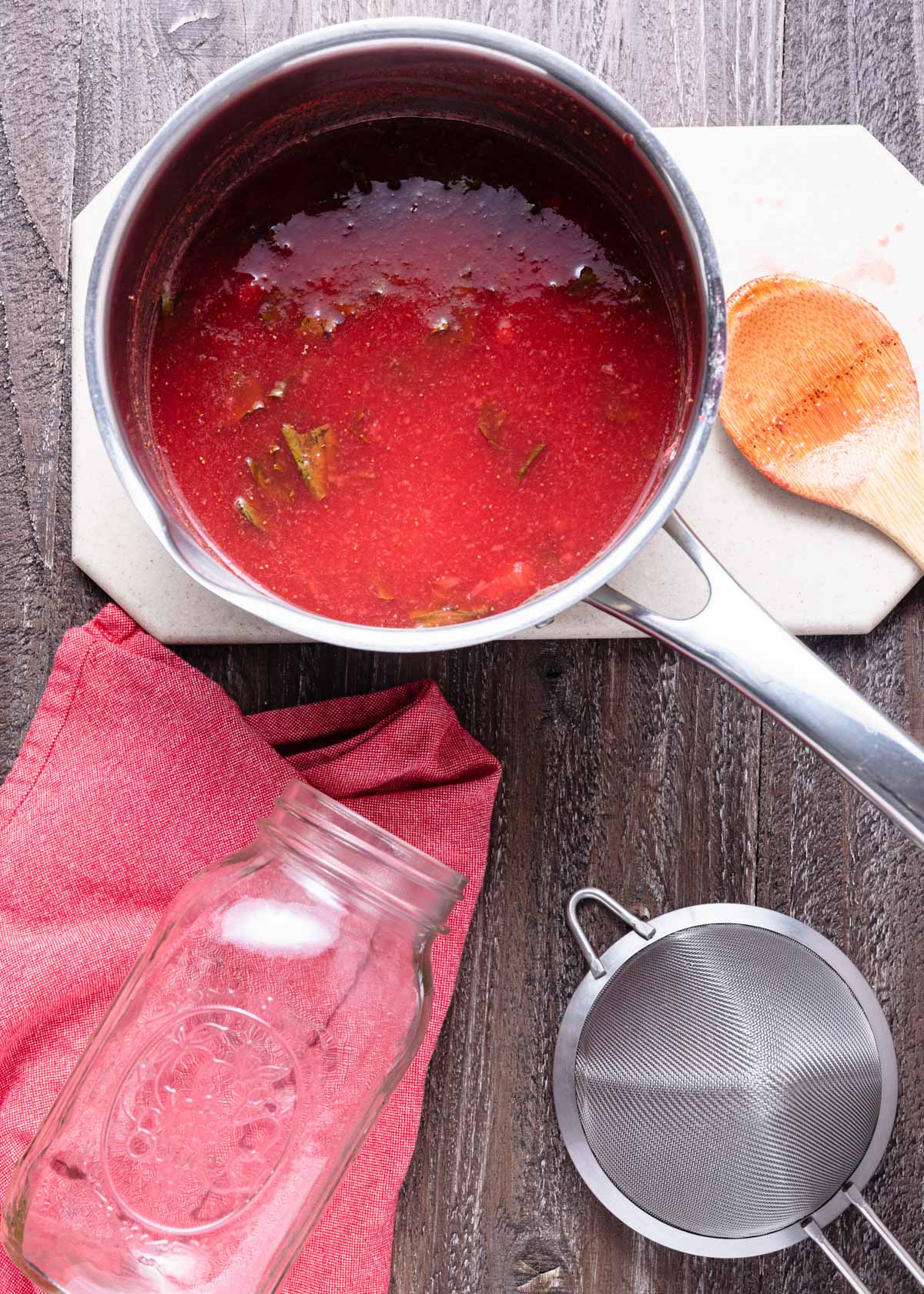 overhead photo of simmered basil strawberry syrup in a saucepan