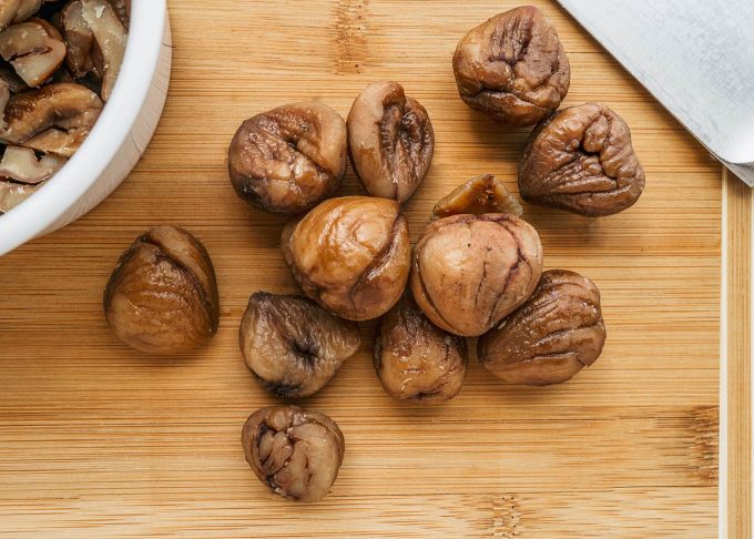 whole chestnuts on a wood cutting board