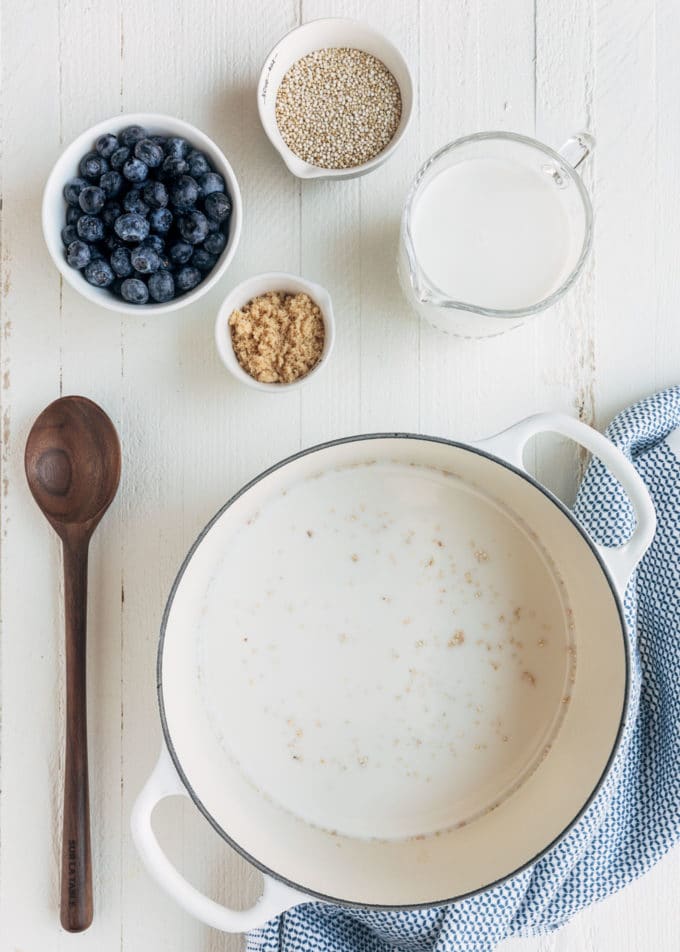 ingredients for blueberry breakfast quinoa on a white wood board