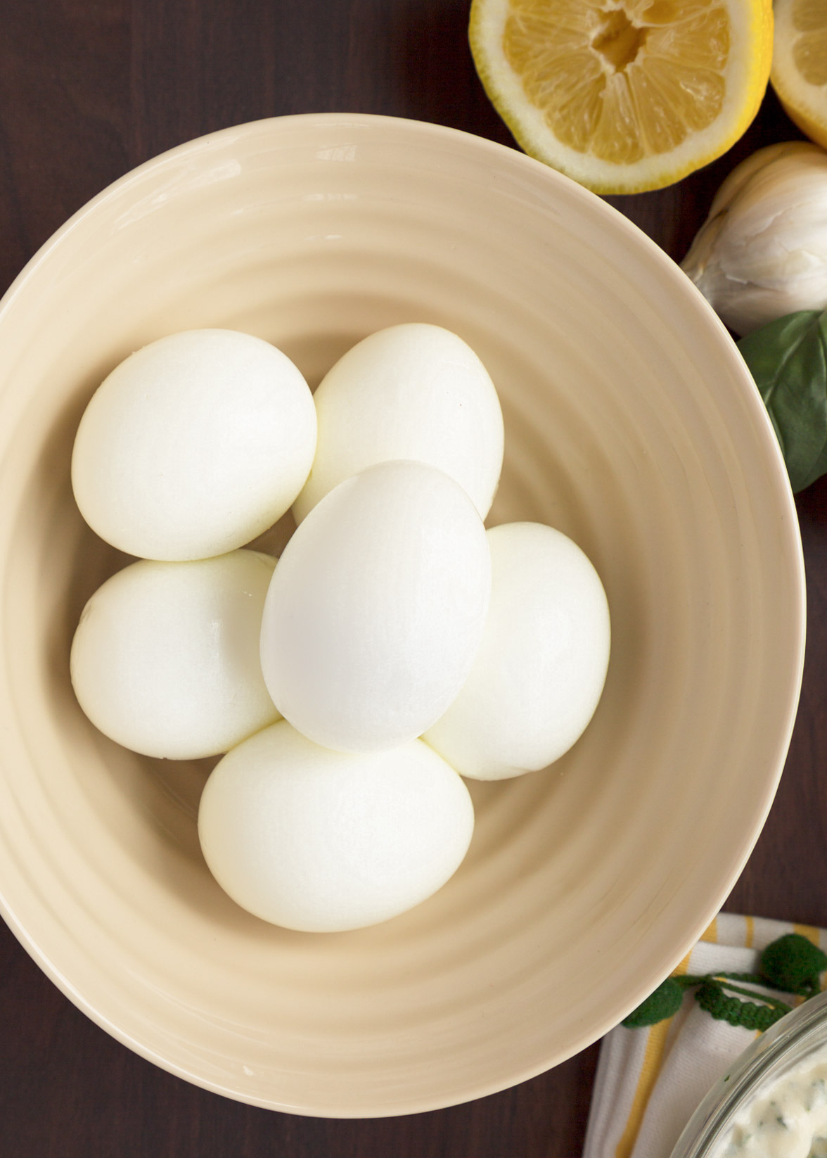 six hard boiled eggs in an ivory ceramic bowl (overhead)