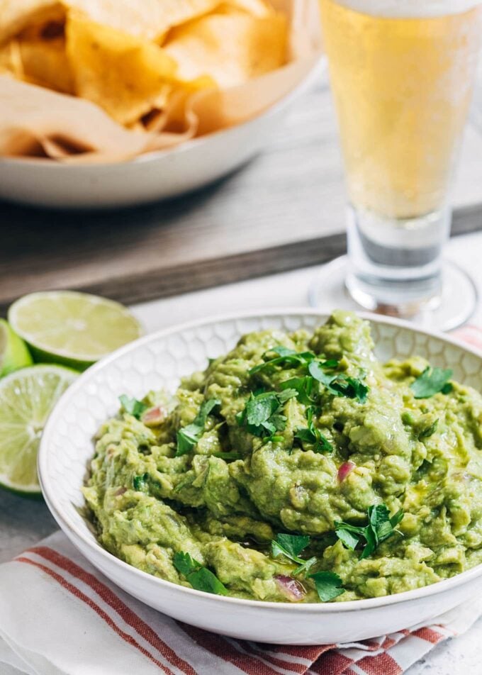 grilled guacamole in a serving bowl with a dish of tortilla chips