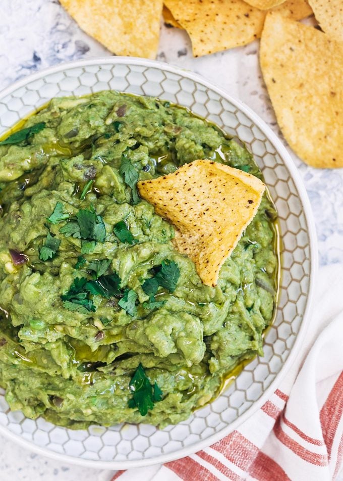 grilled avocado guacamole in a bowl with a tortilla chip