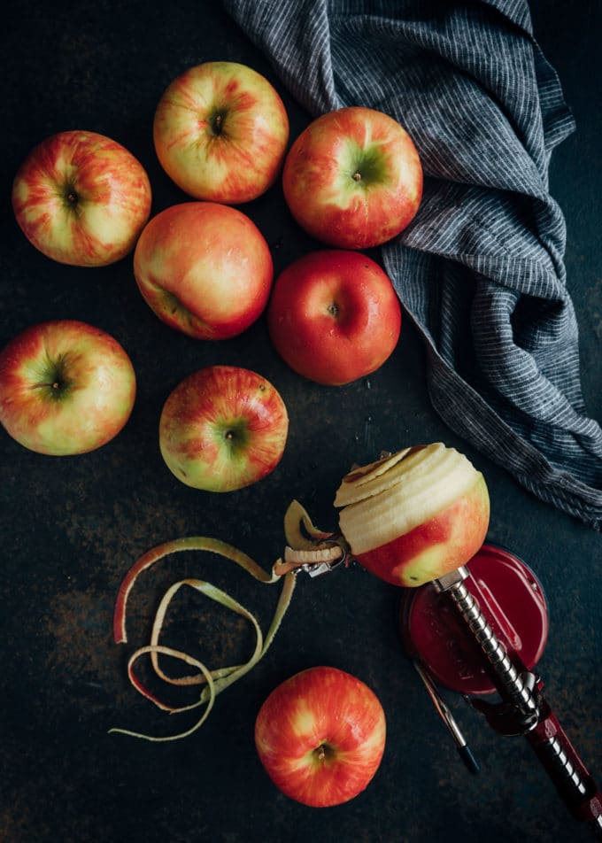 apples on a dark board with an apple peeler tooler