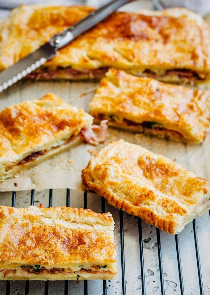 strips of ham and cheese puff pastry on a cooling rack