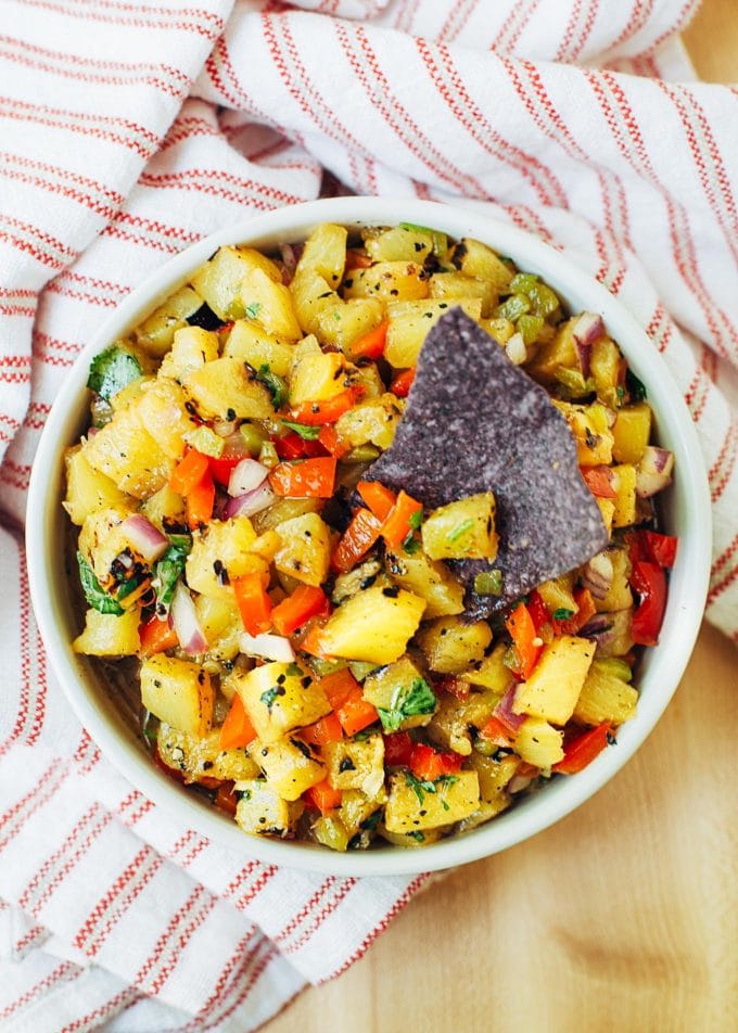 pineapple salsa in a bowl with a blue corn chip