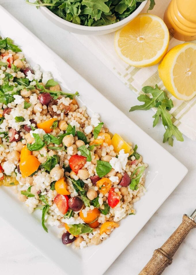 mediterranean pearled couscous salad on a white platter