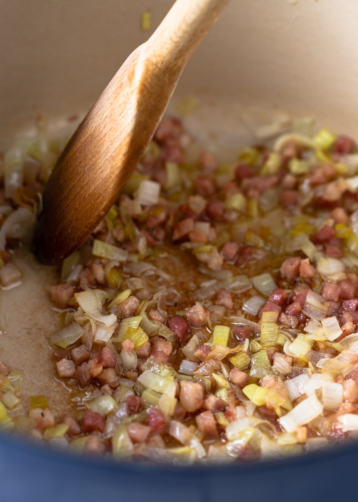 sauteeing leeks and pancetta in an enameled cast iron pot