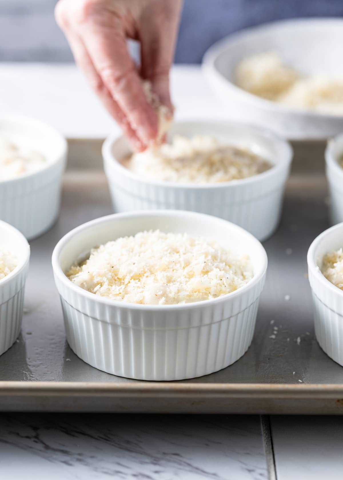 unbaked gourmet mac and cheese in white ramekins with panko breadcrumb topping