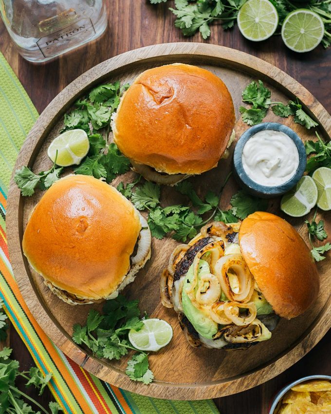 mojo beef burgers on serving tray with a bowl of tequila lime aioli