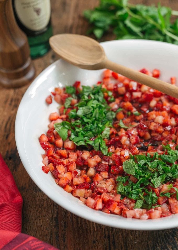 chopped strawberries with basil and mint in a bowl