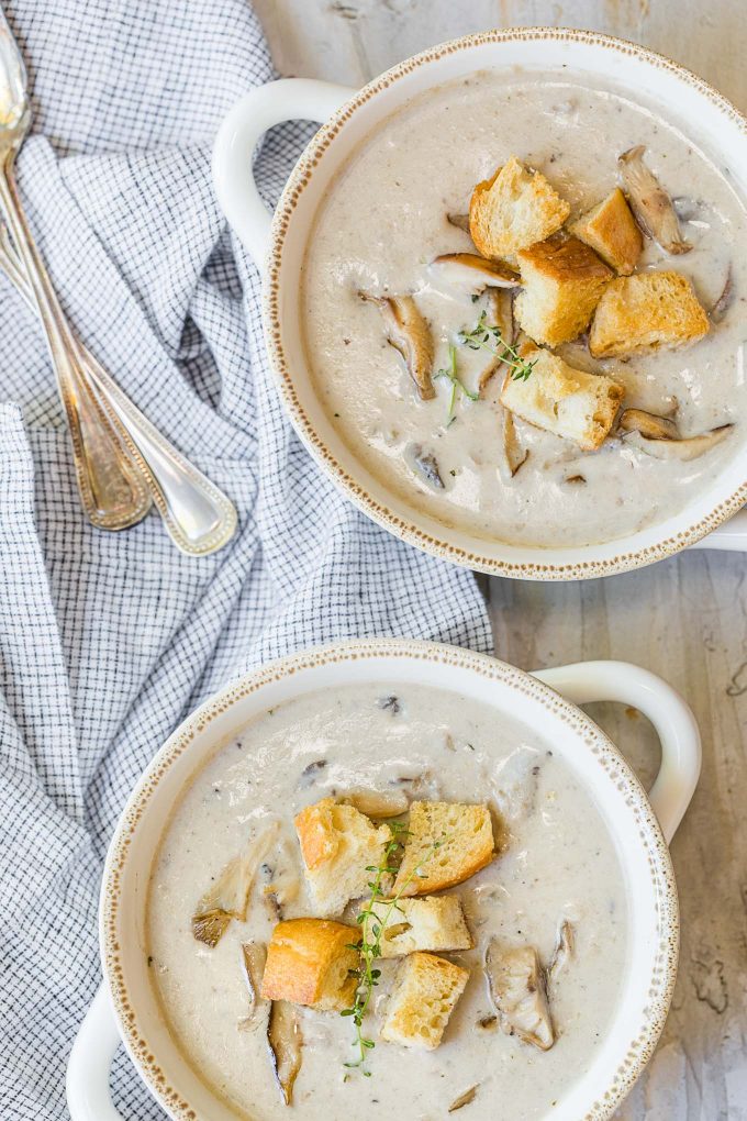 cream of mushroom soup served in two white bowls with croutons