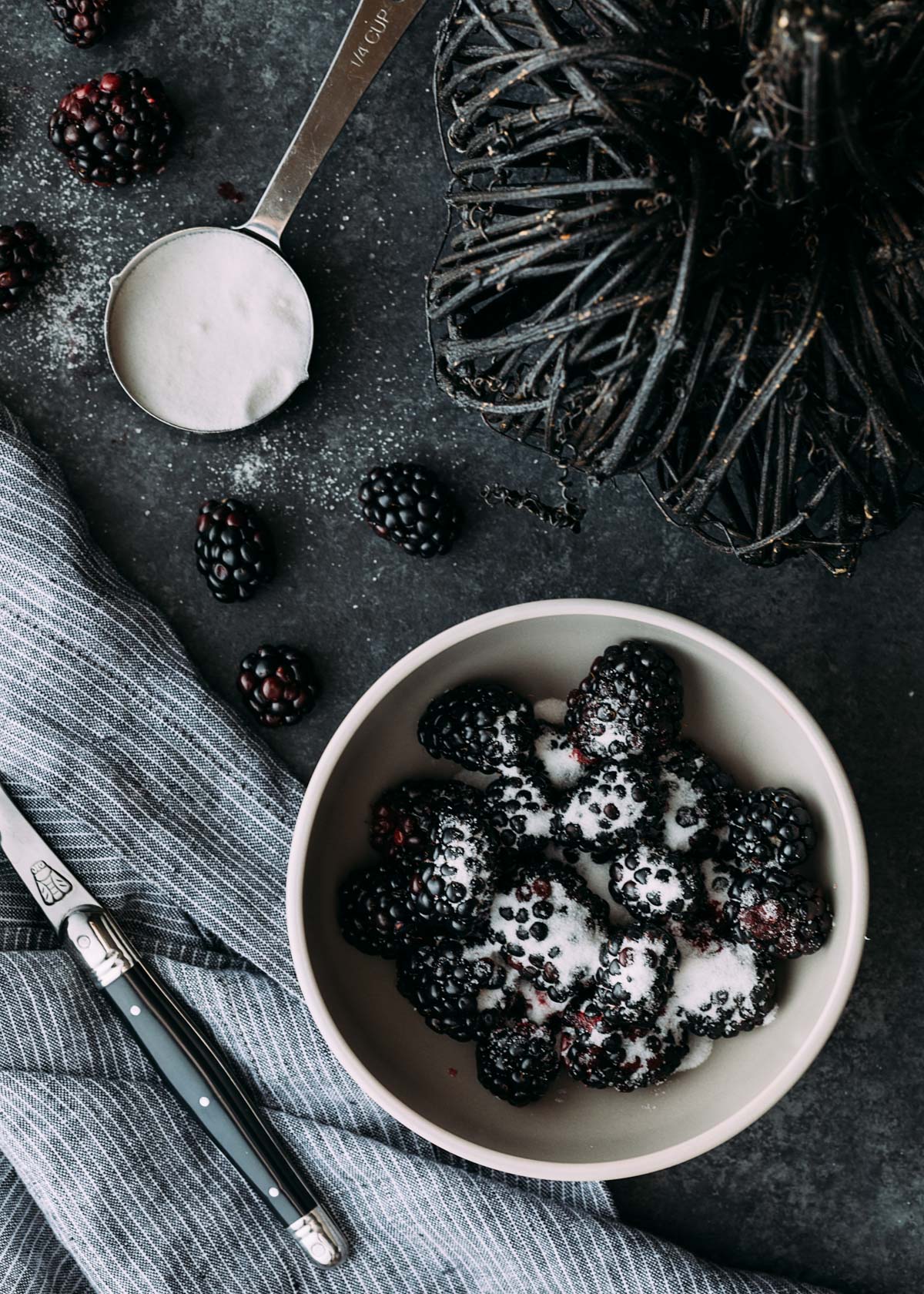 blackberries being macerated in a bowl with granulated sugar