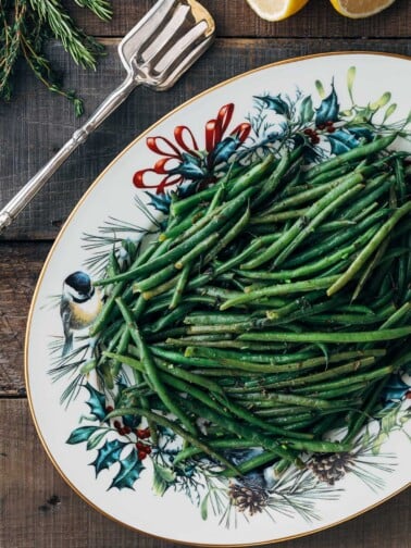 haricots verts on a Christmas serving platter with silver serving tongs