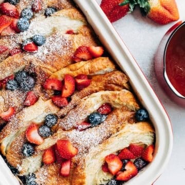 overhead of a croissant french toast bake with berries in a staub rectangular baker