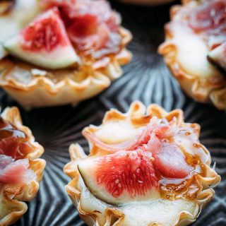 miniature phyllo brie bites with figs and prosciutto on a serving tray