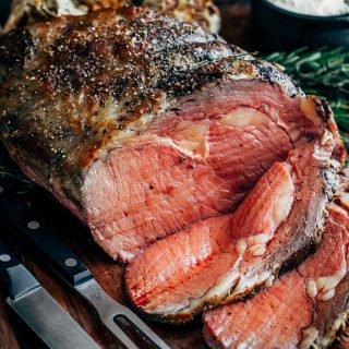 partially sliced slow roasted prime rib on a carving board