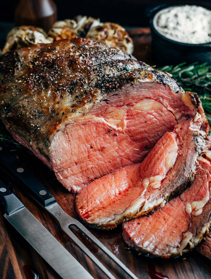 partially sliced slow roasted prime rib on a carving board