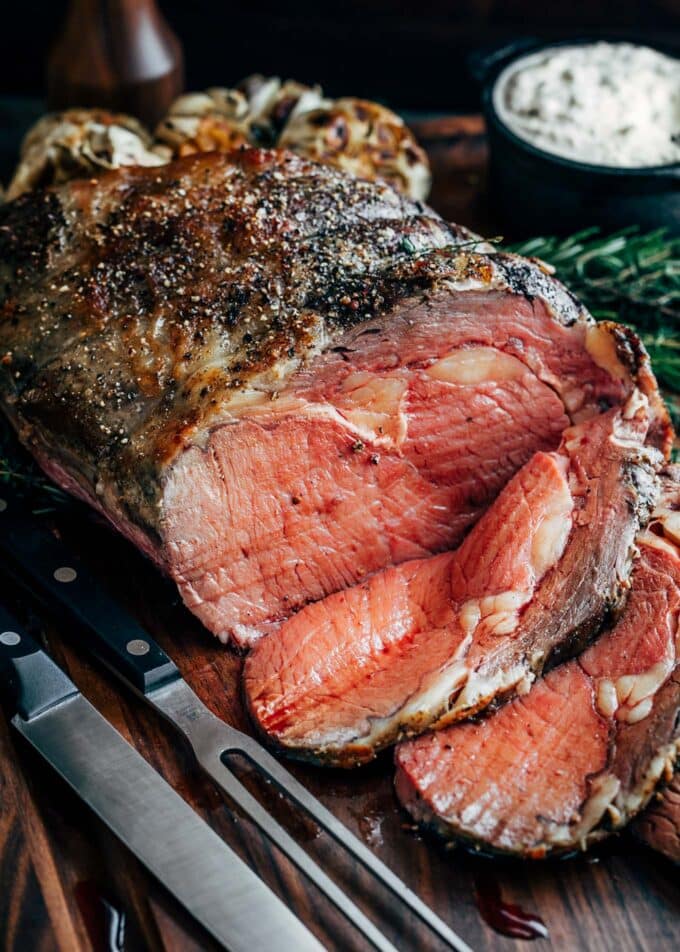 partially sliced slow roasted prime rib on a carving board