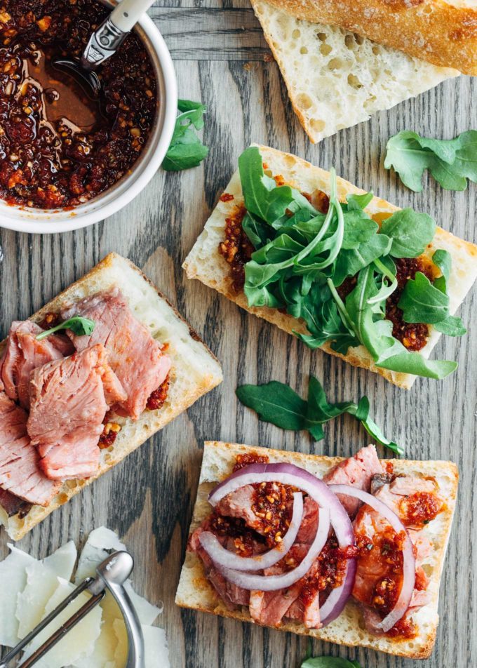 assembly of roast beef sandwiches on a wood board