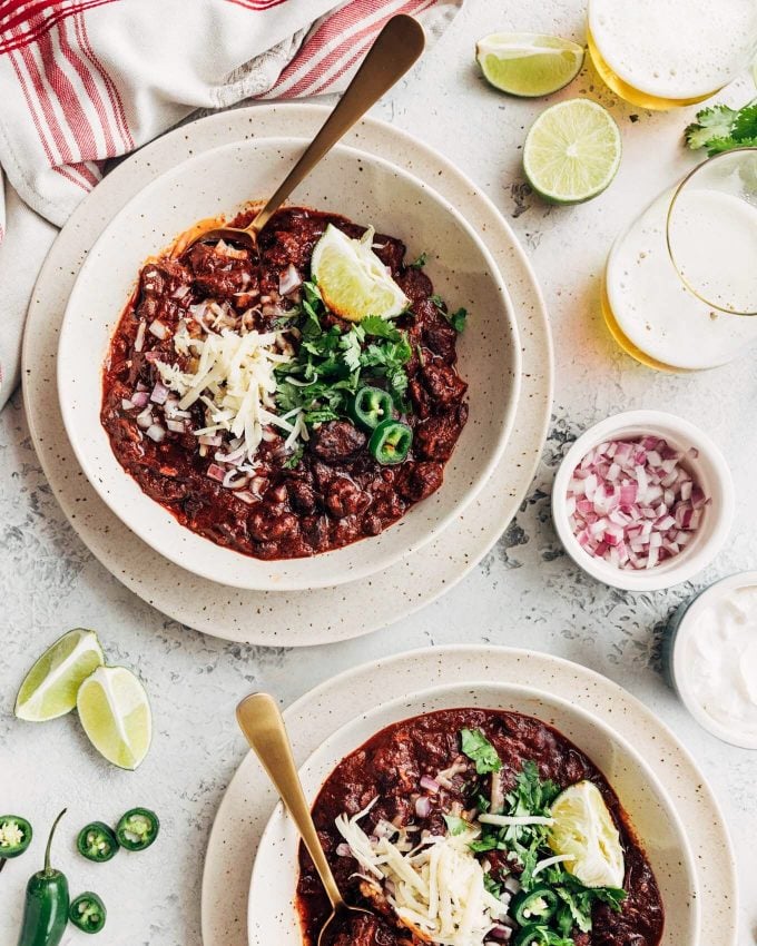 Instant Pot Chili Con Carne served with cheese, onion, lime, and sour cream