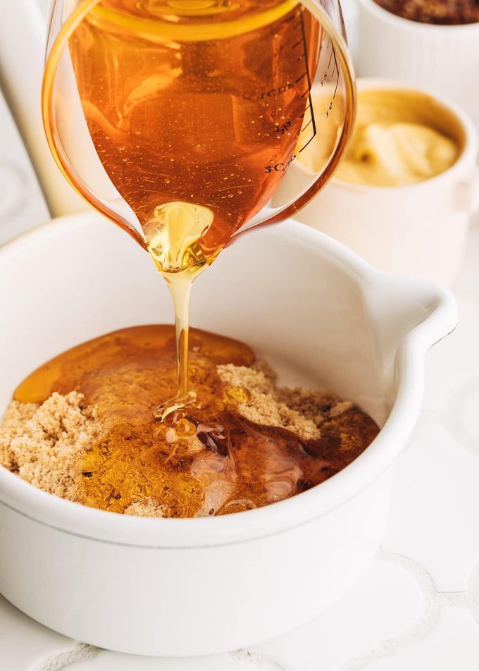 pouring honey into honey mustard glaze for ham