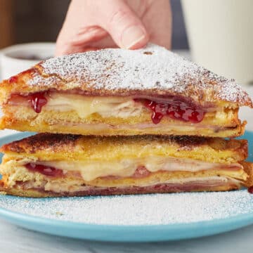 monte cristo sandwich on a teal plate with powdered sugar