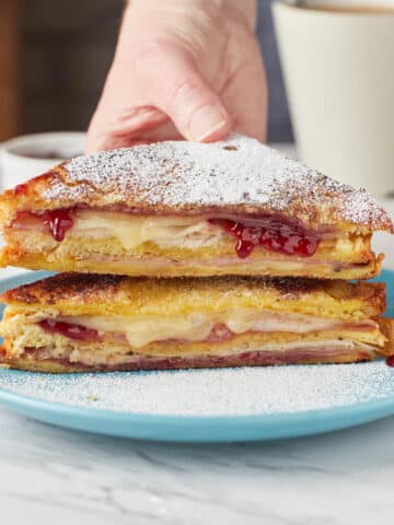monte cristo sandwich on a teal plate with powdered sugar