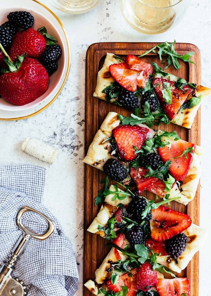 grilled pizza with summer berries and arugula on a wood serving board {sponsored}