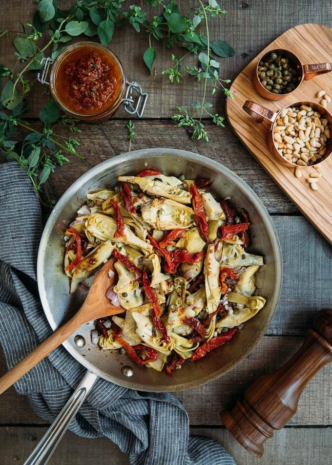 sauteed artichokes and sun dried tomatoes in a saute pan