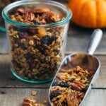 pumpkin granola in a scoop and glass storage jars