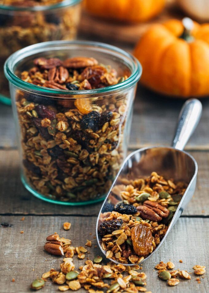 pumpkin granola in a scoop and glass storage jars