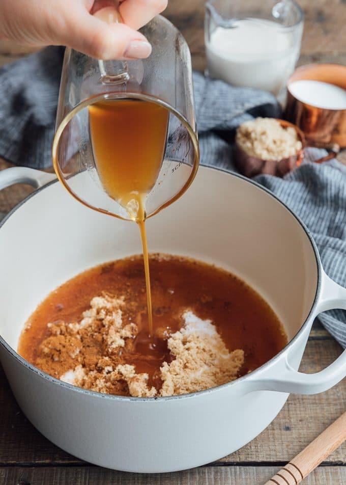 boiled apple cider being poured into a pot to make caramel