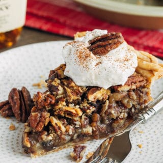 slice of chocolate pecan pie on a plate with whipped cream