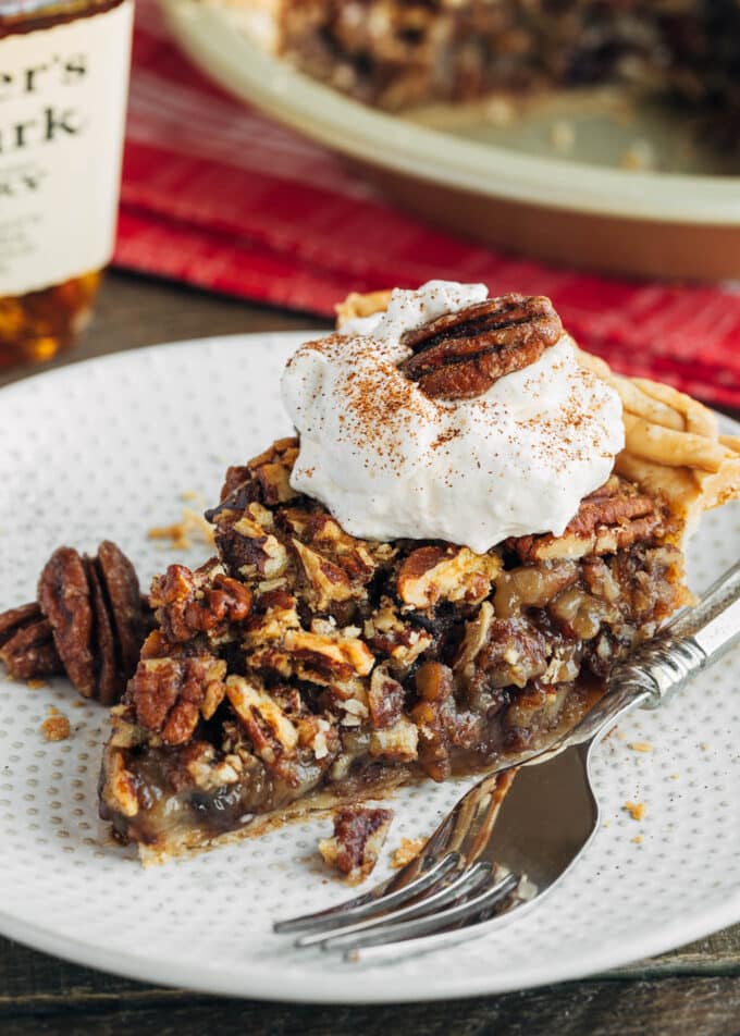 slice of chocolate pecan pie on a plate with whipped cream