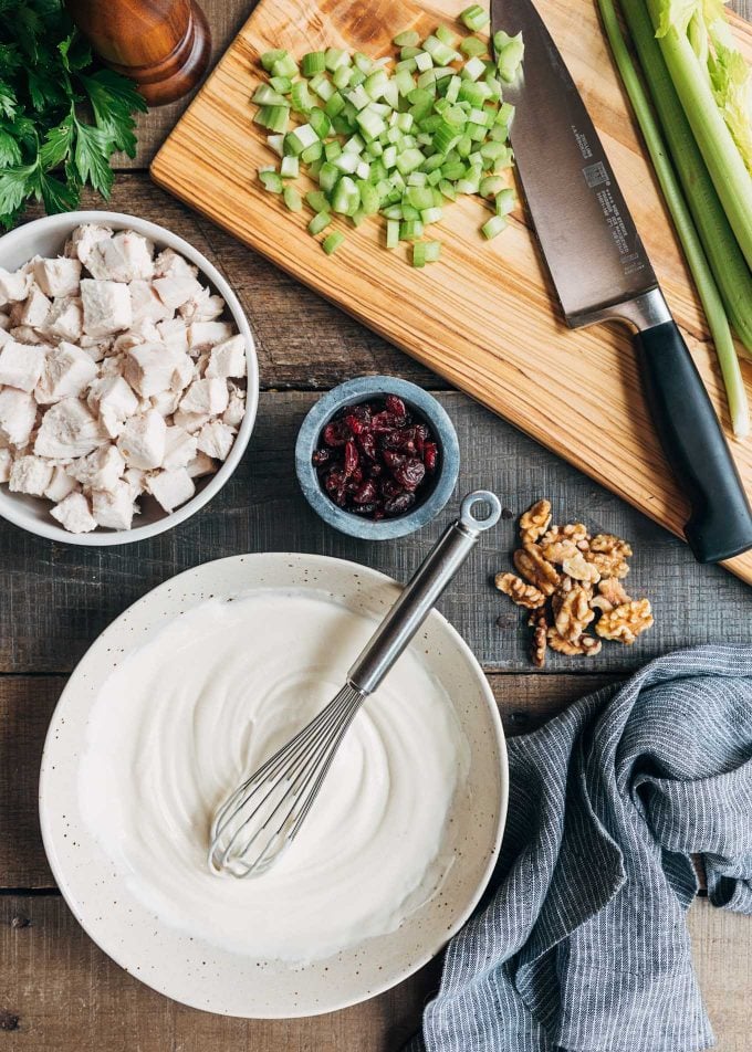 Ingredients for Cranberry Pecan Chicken Salad on a wood board