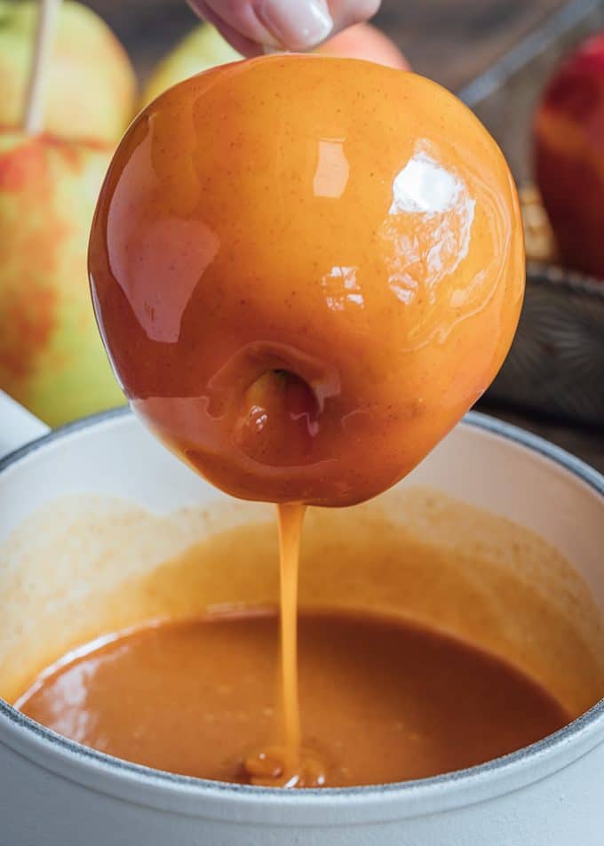 dipping a honeycrisp apple in apple cider caramel