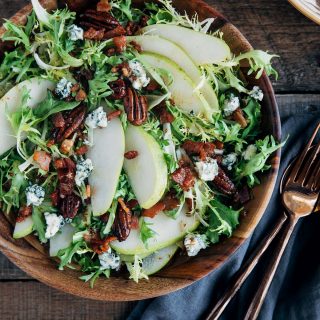 pear salad with warm bacon vinaigrette in a wooden bowl