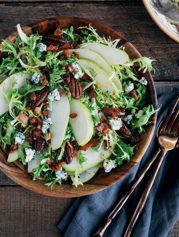 pear salad with warm bacon vinaigrette in a wooden bowl