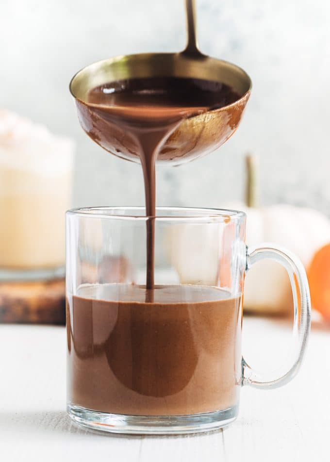 pouring dark chocolate pumpkin spice hot chocolate with a ladle