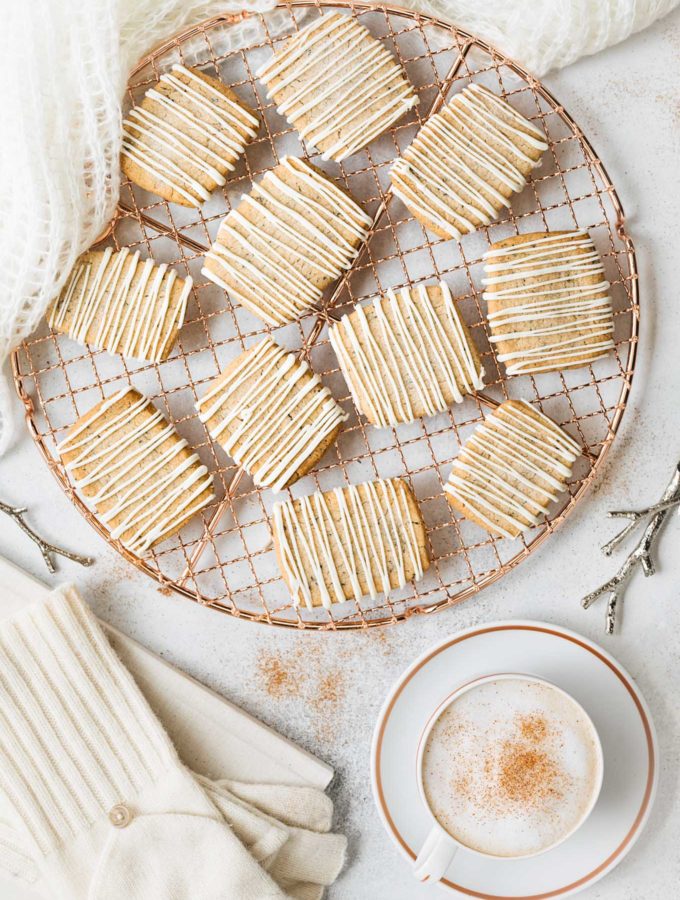chai spice shortbread cookies with white chocolate drizzle on a cooling rack