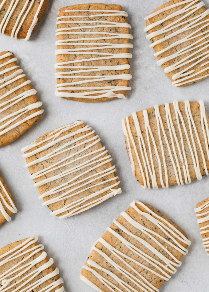 white chocolate drizzled shortbread cookies on a baking sheet