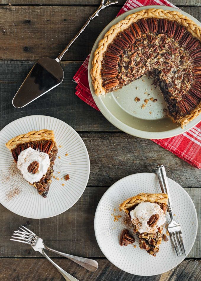 slices of chocolate pecan pie with whipped cream on plates