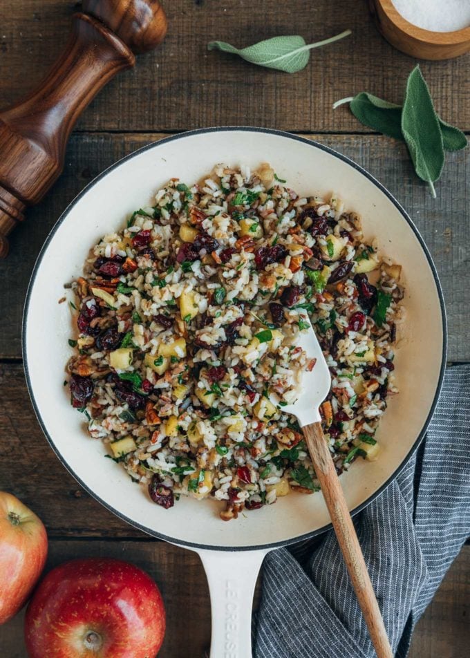 rice stuffing for cornish hens with cranberries and apples in a white pan