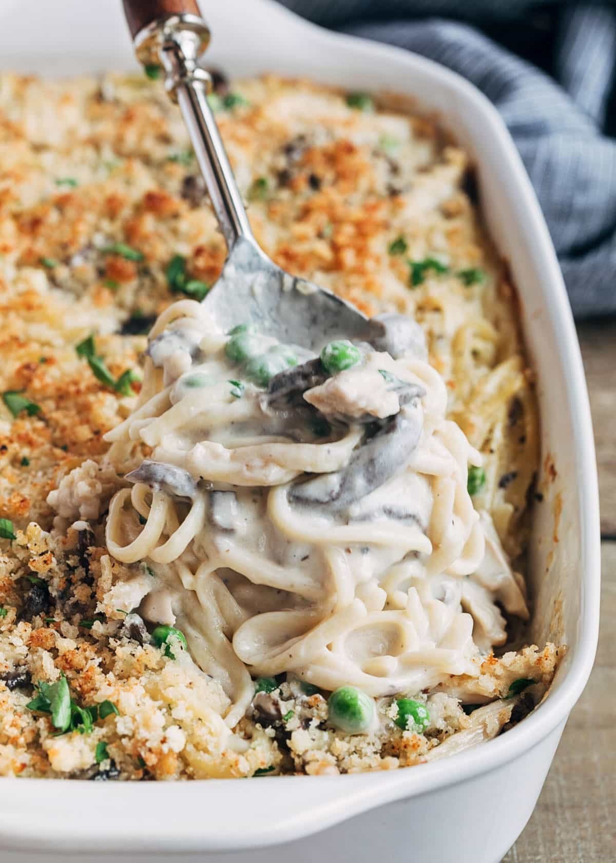 baked turkey tetrazzini being scooped from a white baking dish