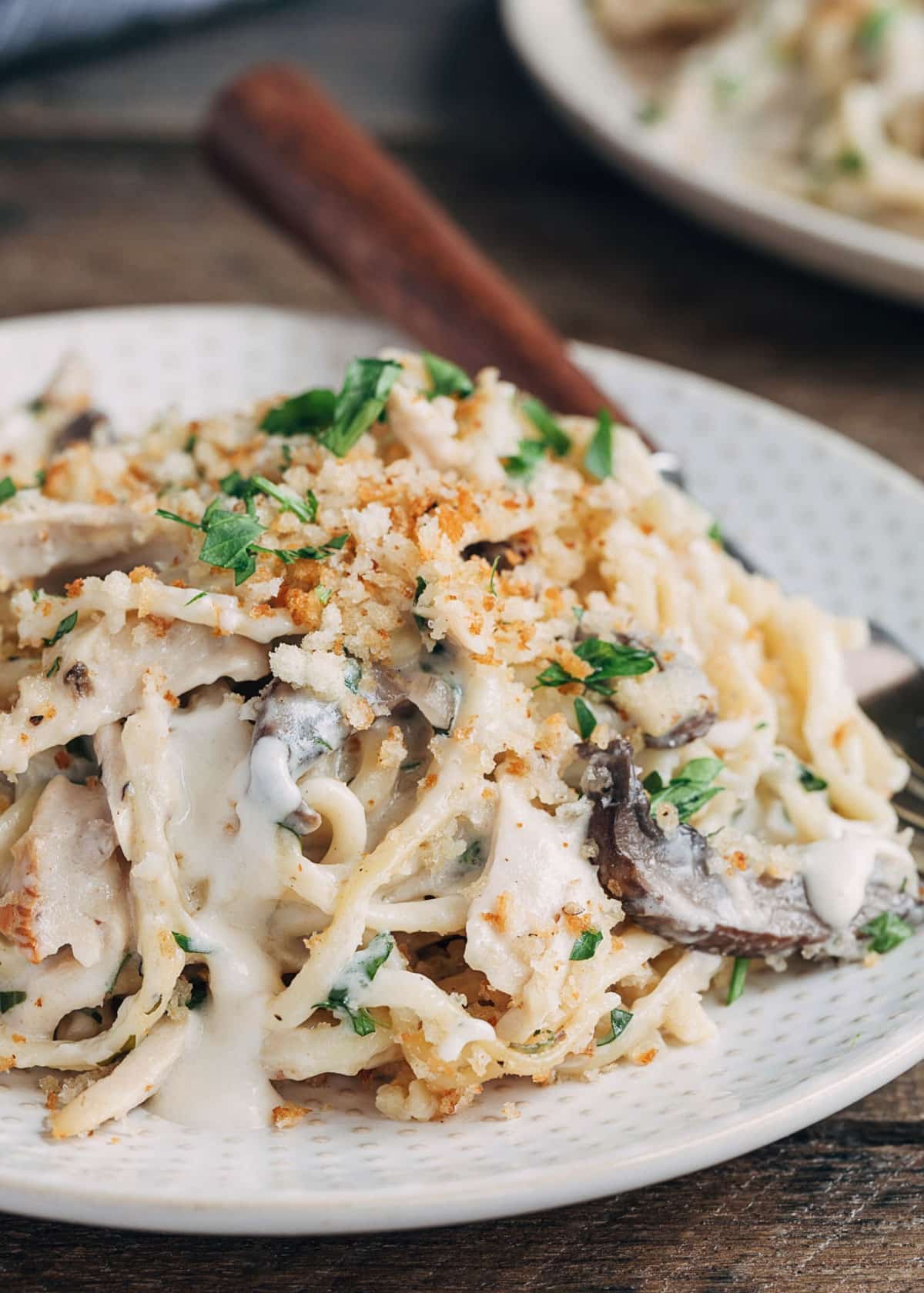 closeup of turkey tetrazzini on a plate with mushrooms and peas