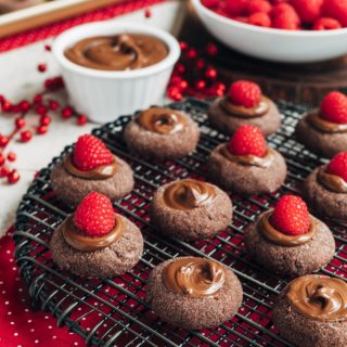 chocolate thumbprint cookies with raspberries and nutella on a cooling rack {sponsored}